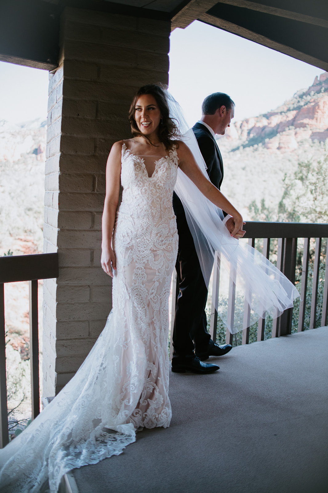 Bride standing on a Sedona Airbnb balcony with flowing veil and red rock views during an elopement in Arizona
