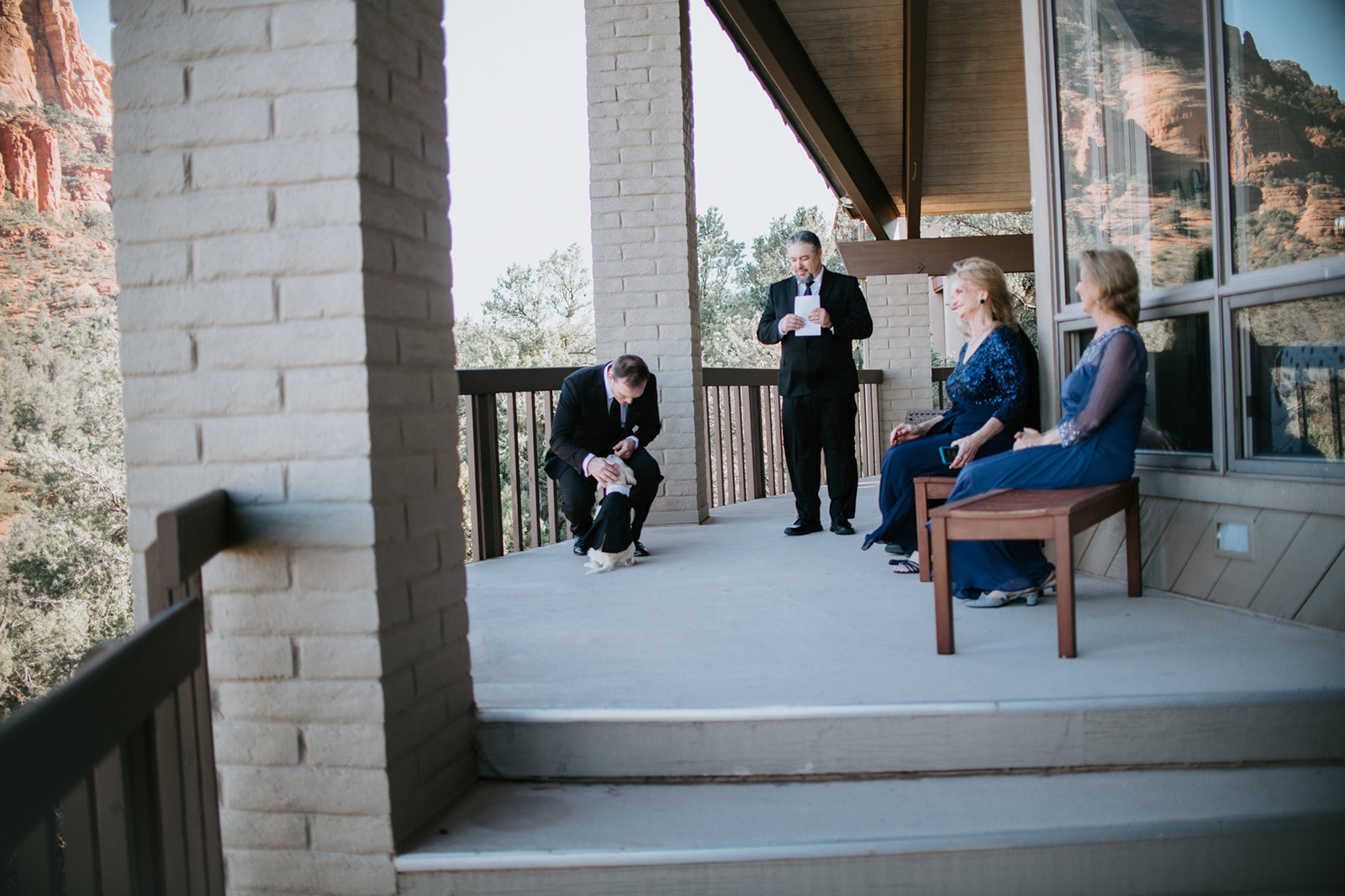 Small Airbnb ceremony setup with family seated on a balcony overlooking Sedona red rocks