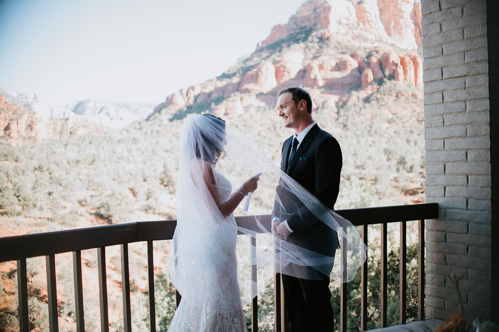 Bride reading vows on a balcony with desert views during a Sedona Arizona elopement
