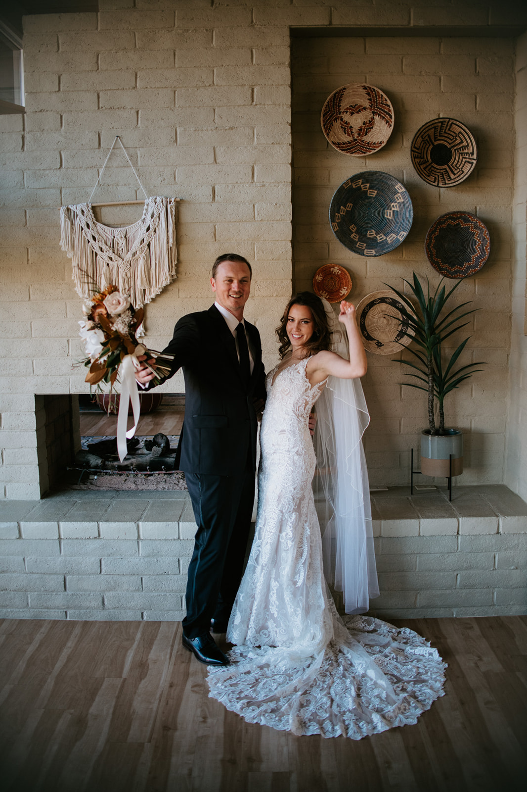 Bride and groom celebrating indoors with champagne in a cozy Airbnb space with desert-inspired decor

