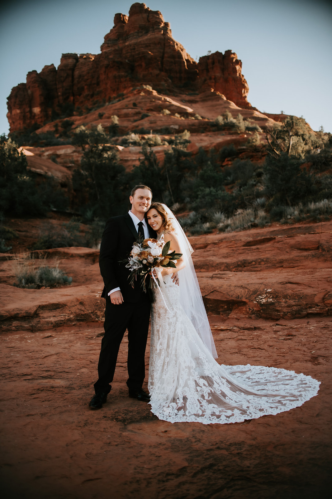 Bride and groom standing together on red rocks after their Sedona elopement ceremony
