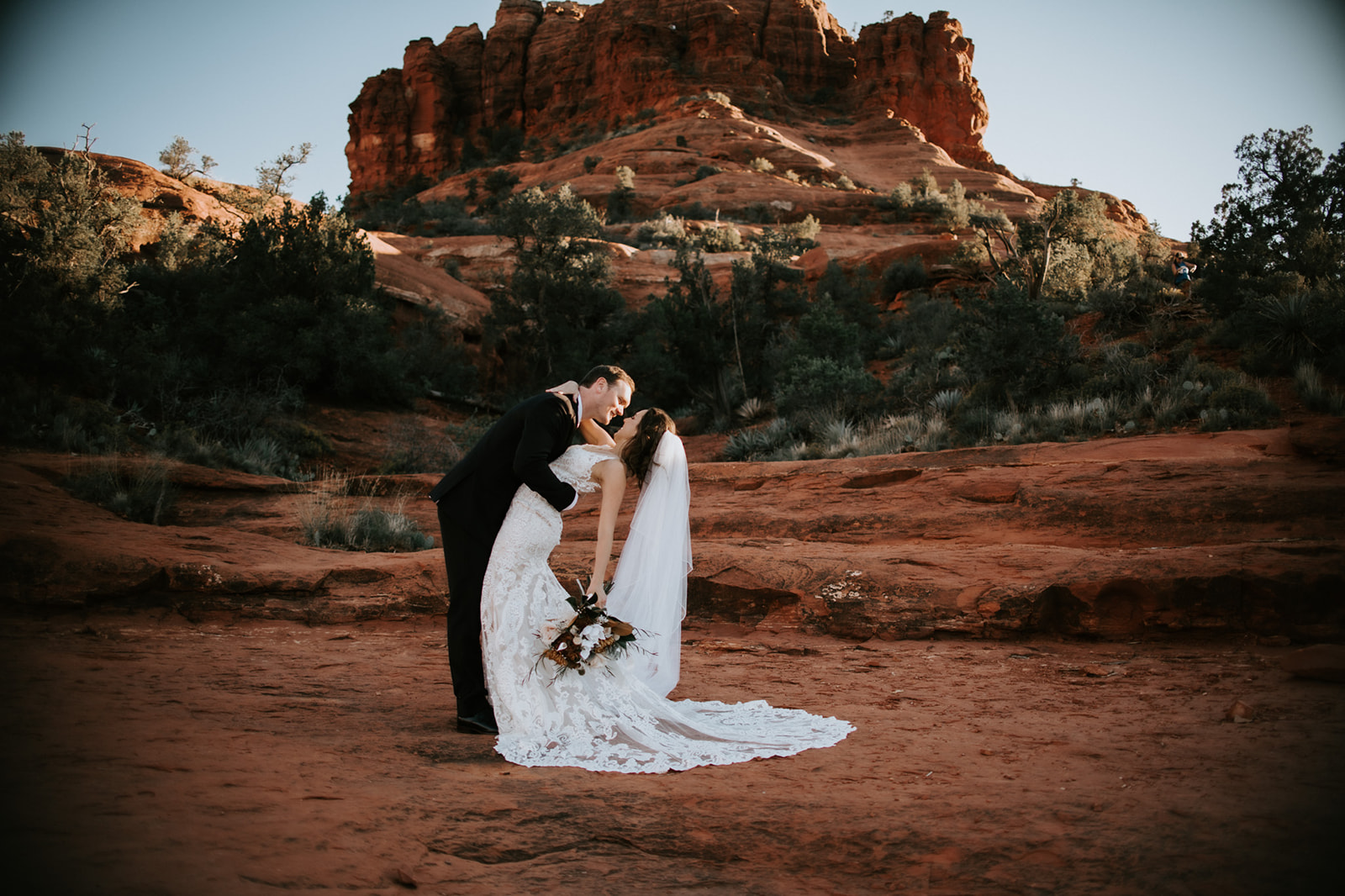 Groom dipping bride during a romantic moment on red rocks in Sedona Arizona

