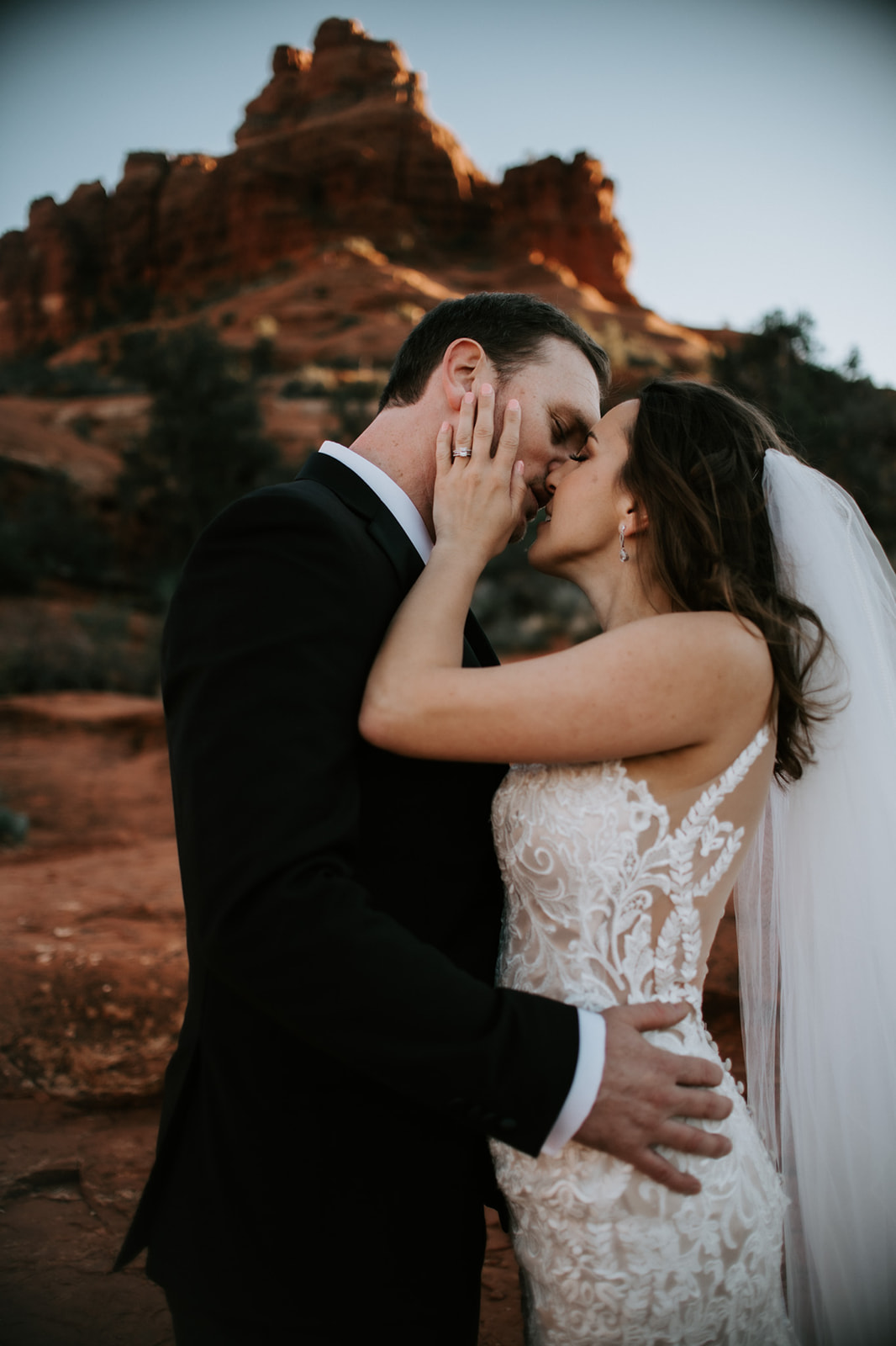 Close-up of couple kissing in front of red rock formations during their elopement in Arizona at sunset
