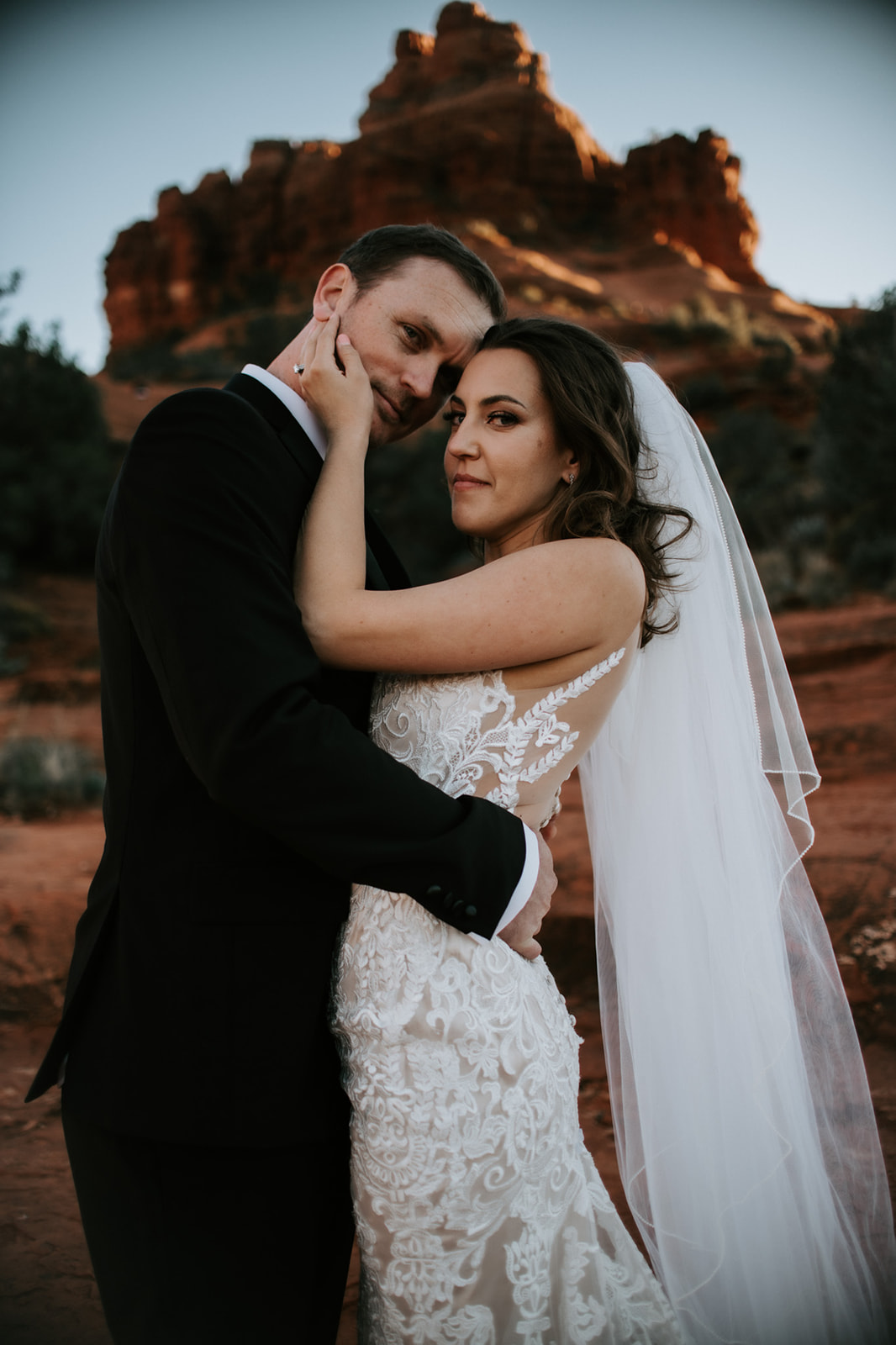 Groom lifting bride during an intimate sunset moment on Sedona red rocks
