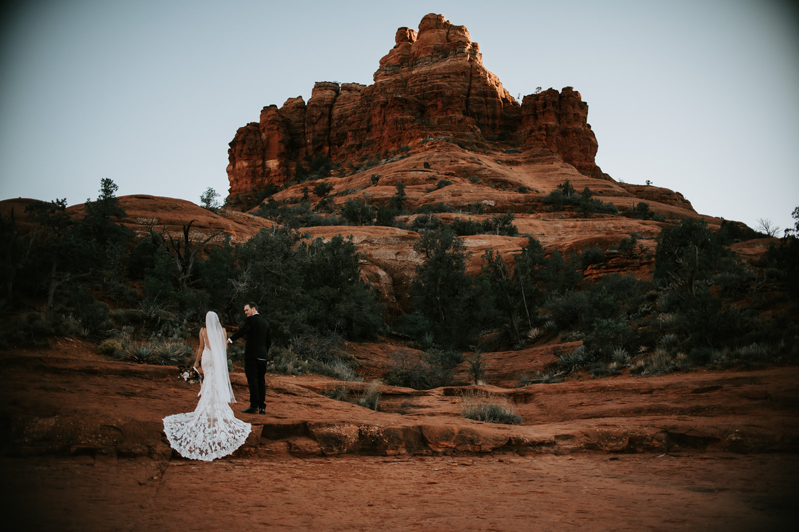 Wide landscape view of couple exploring Sedona red rocks during their elopement