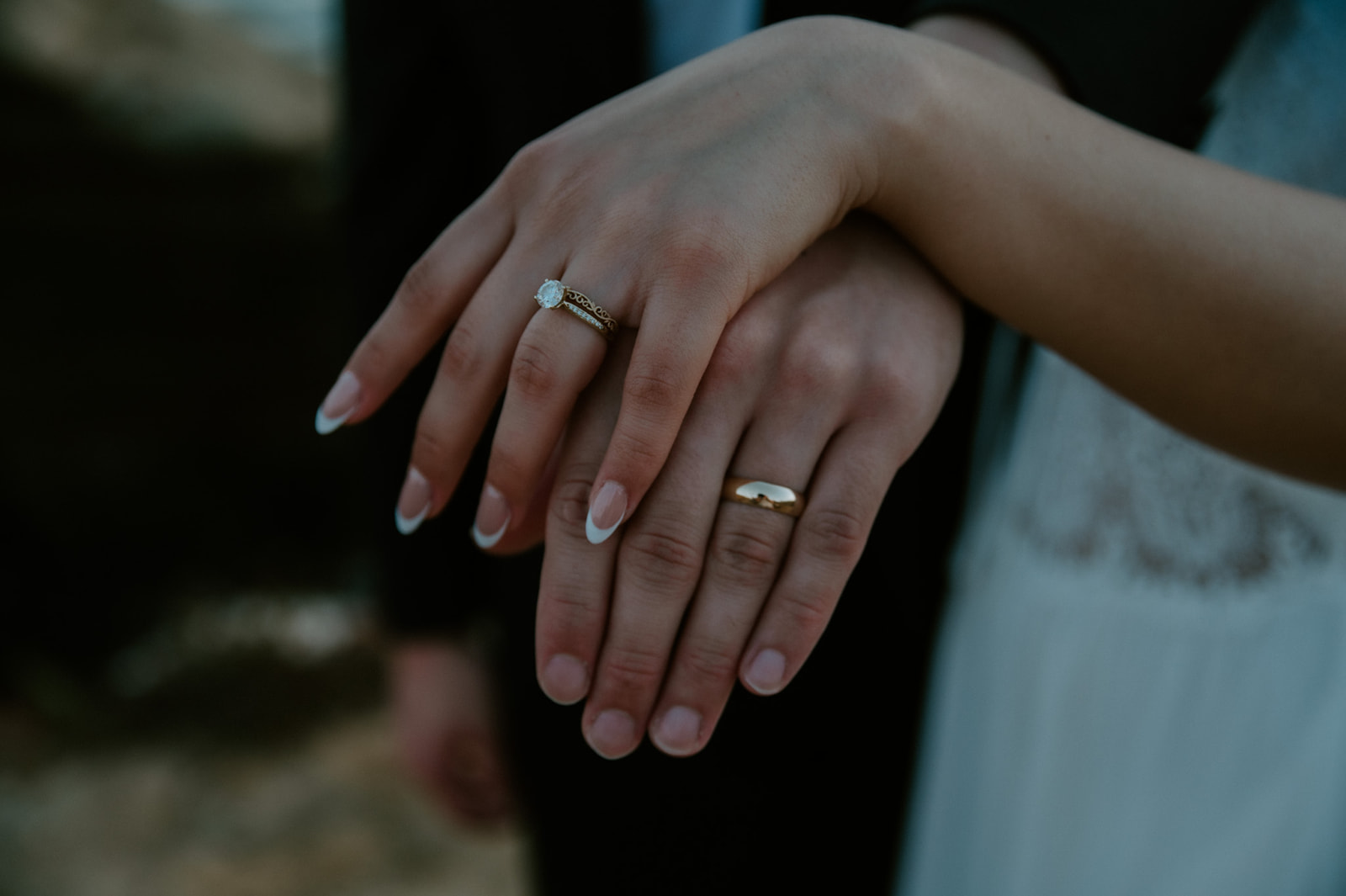 Close-up of hands showing wedding rings, a simple detail often included in an elopement checklist.
