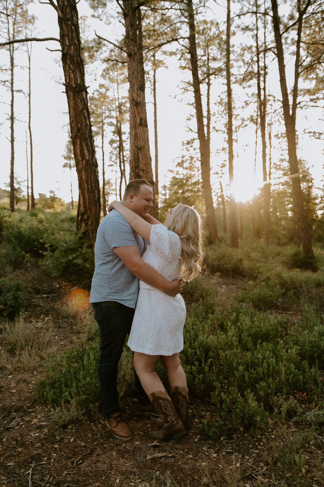 Romantic embrace between a couple in a forest clearing with warm golden hour light
