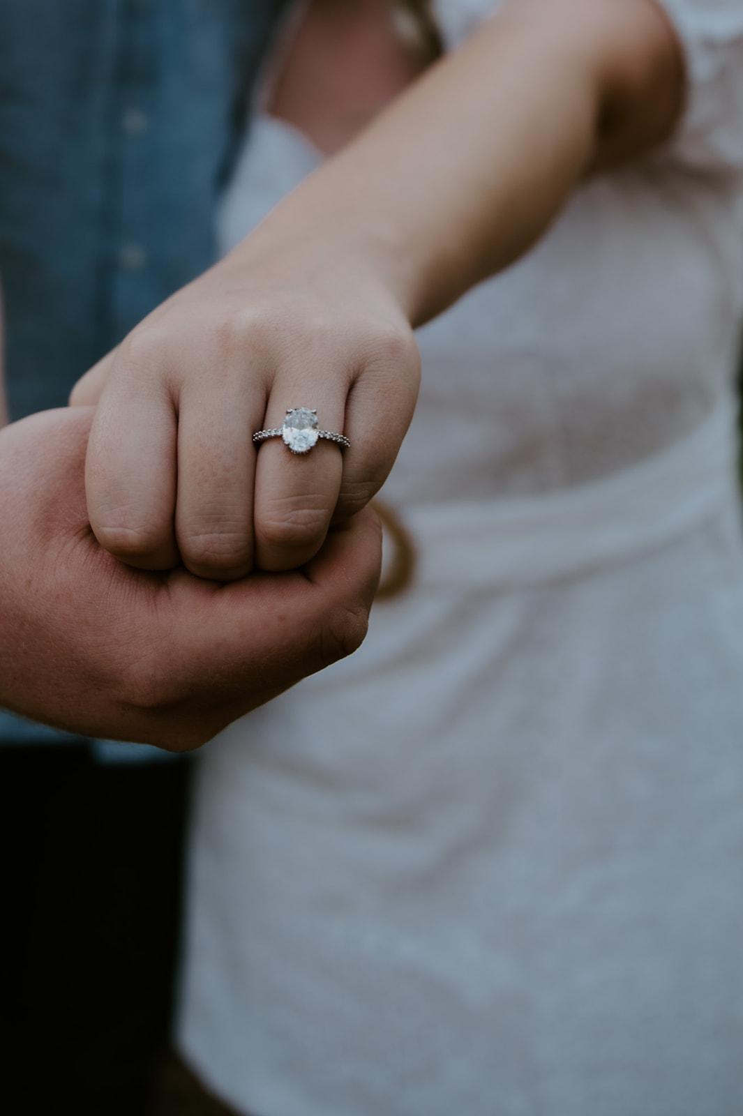 Close-up of an engagement ring as a couple holds hands, a quiet detail from an adventure elopement
