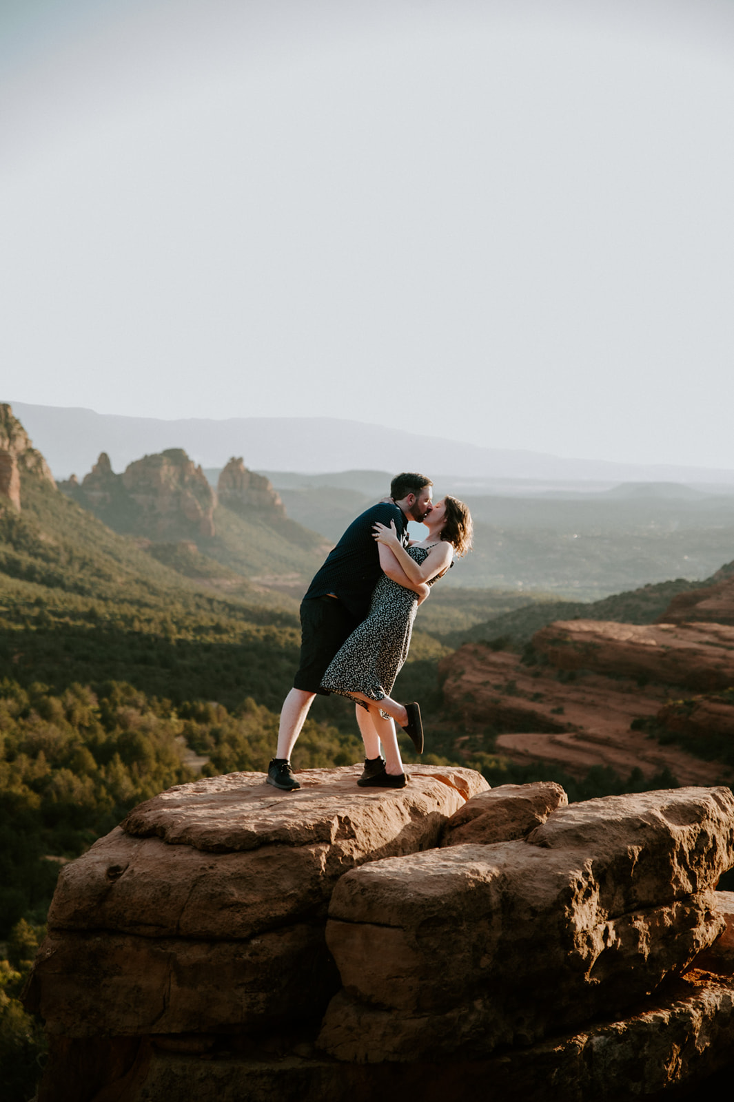 Couple kissing on a cliffside rock formation after choosing to elope to Sedona