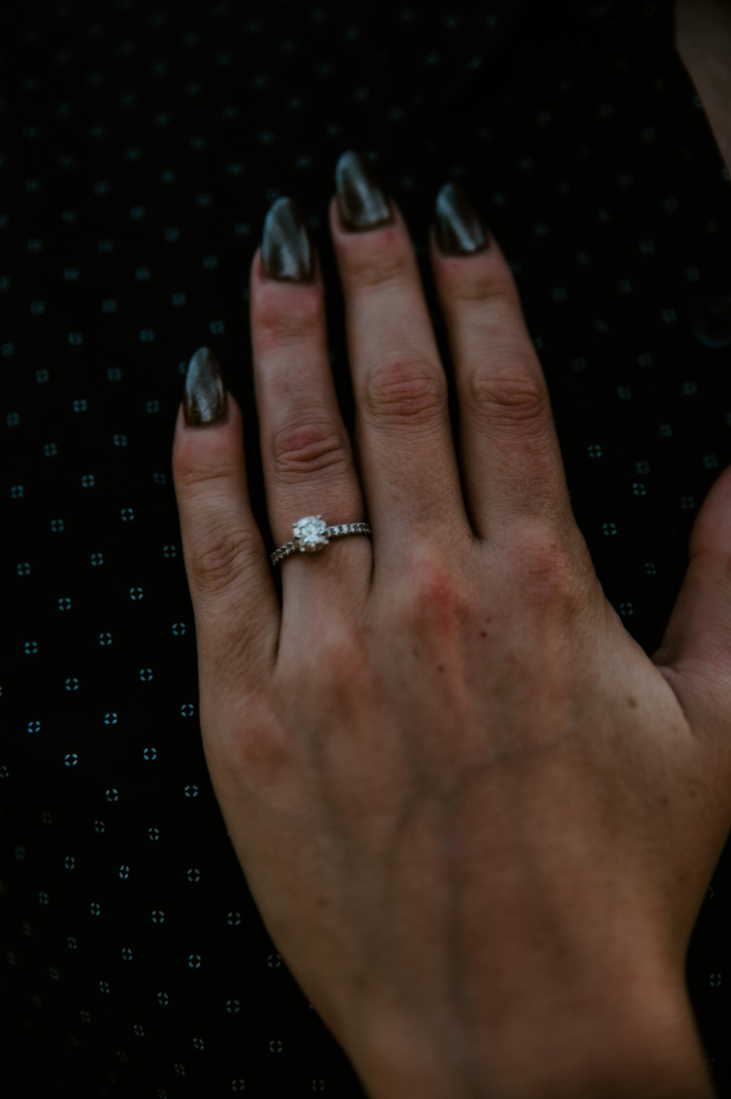 Close-up of an engagement ring on a hand with dark nail polish during a Sedona proposal moment
