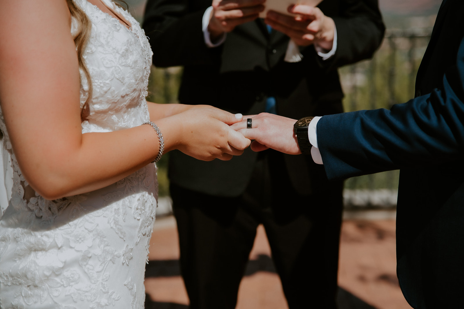 Couple exchanging rings during an outdoor ceremony as they elope to Sedona with a small, intimate setup