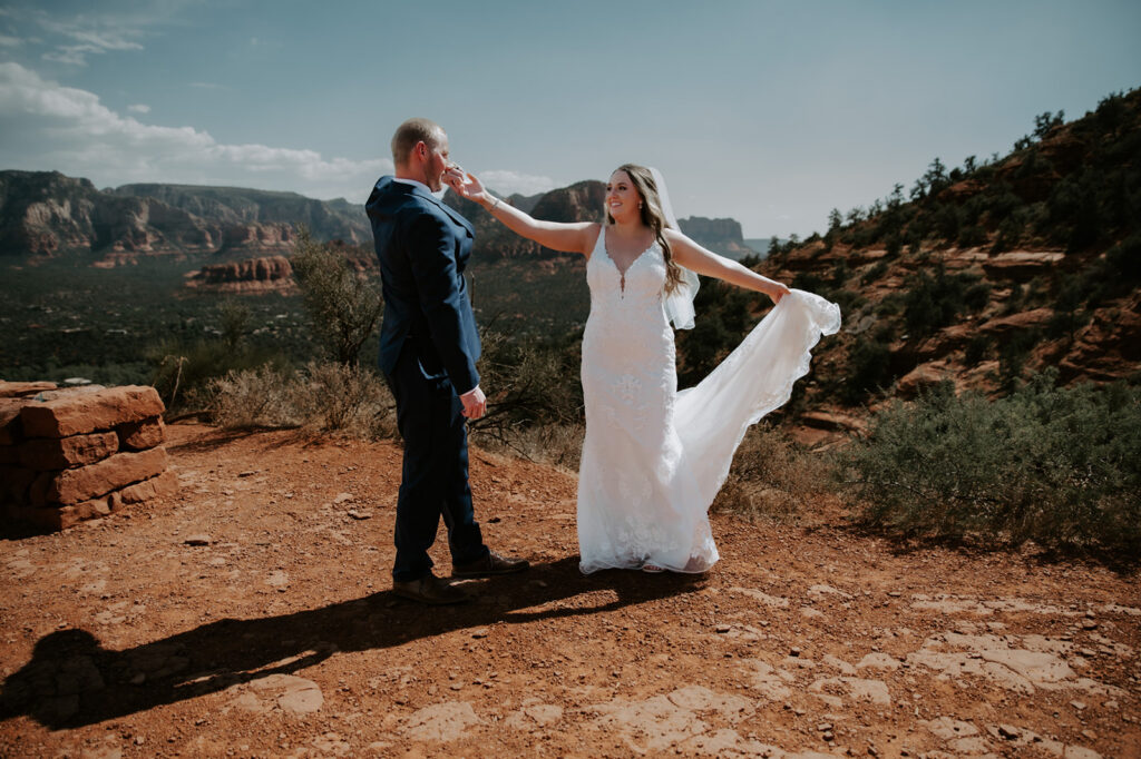Bride and groom celebrating after they elope to Sedona with sweeping red rock views behind them