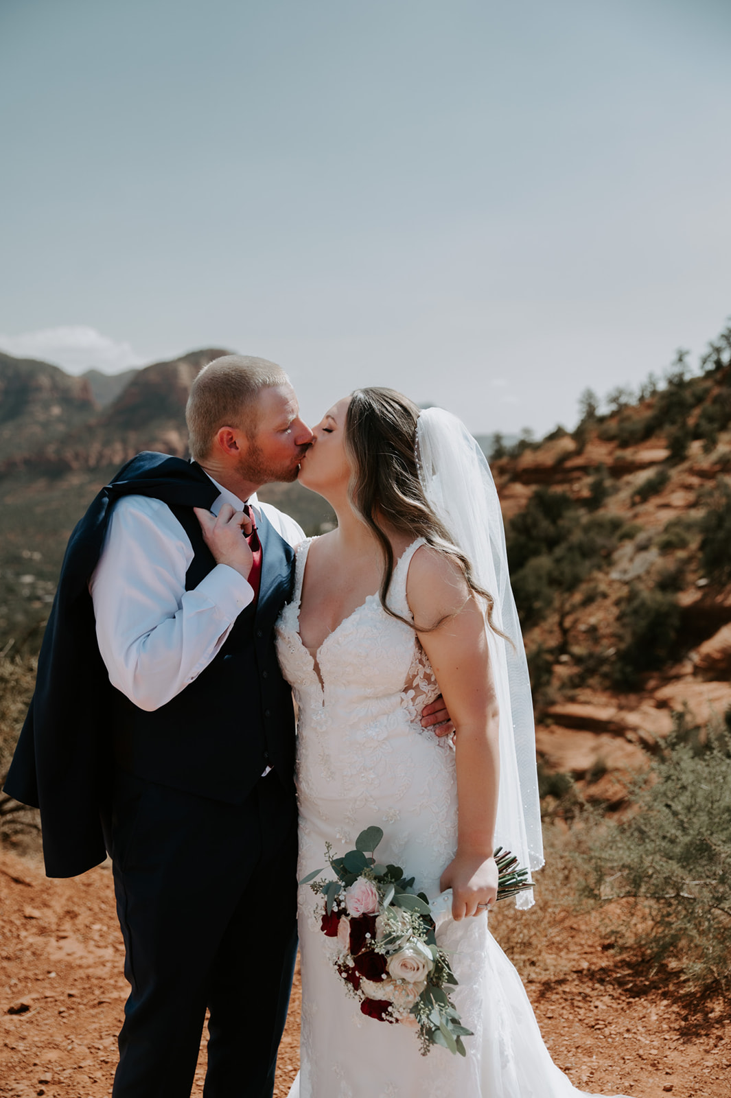 Close-up of a bride and groom kissing with her veil softly framing the moment during their decision to elope to Sedona