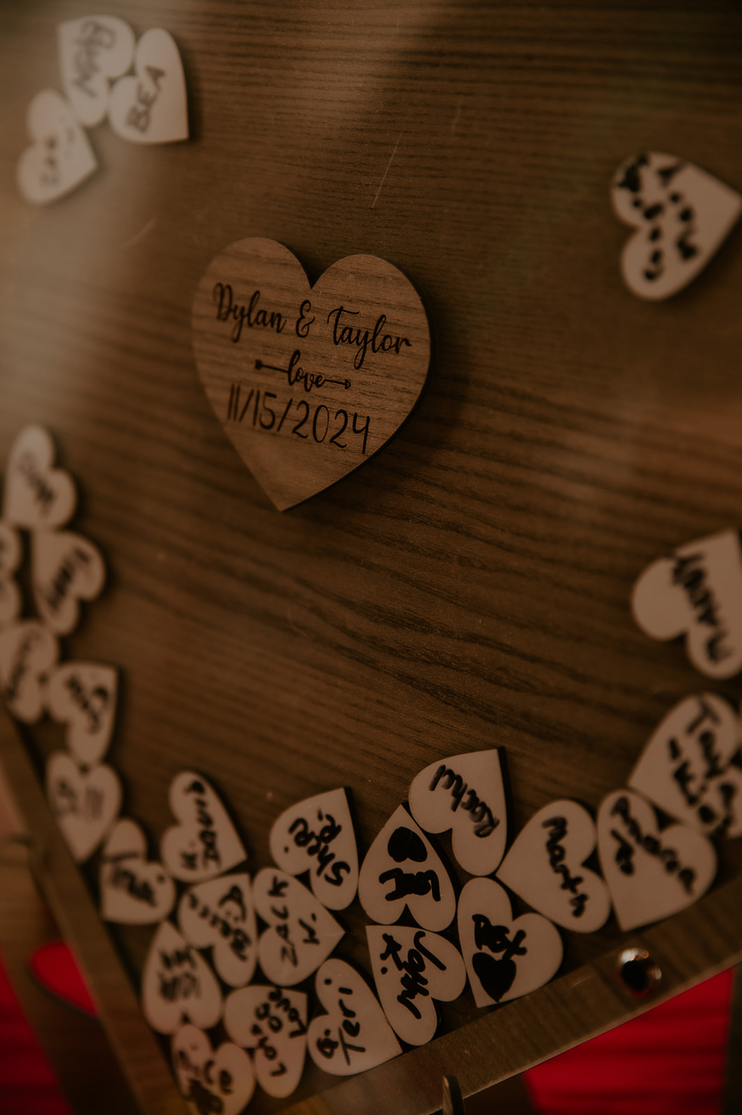 Personalized wooden guestbook display from an LGBTQ wedding celebration with heart-shaped guest notes