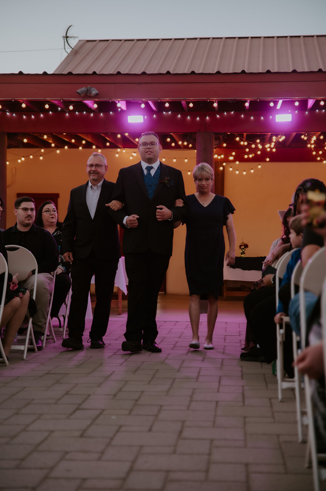 Groom walking down the aisle with family during an emotional outdoor ceremony photographed by an LGBTQ wedding photographer