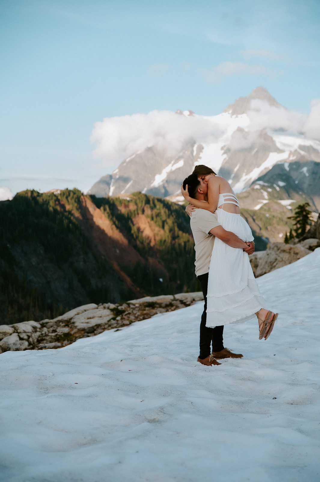 Bride lifted into groom’s arms during a North Cascades elopement in the snow at sunset