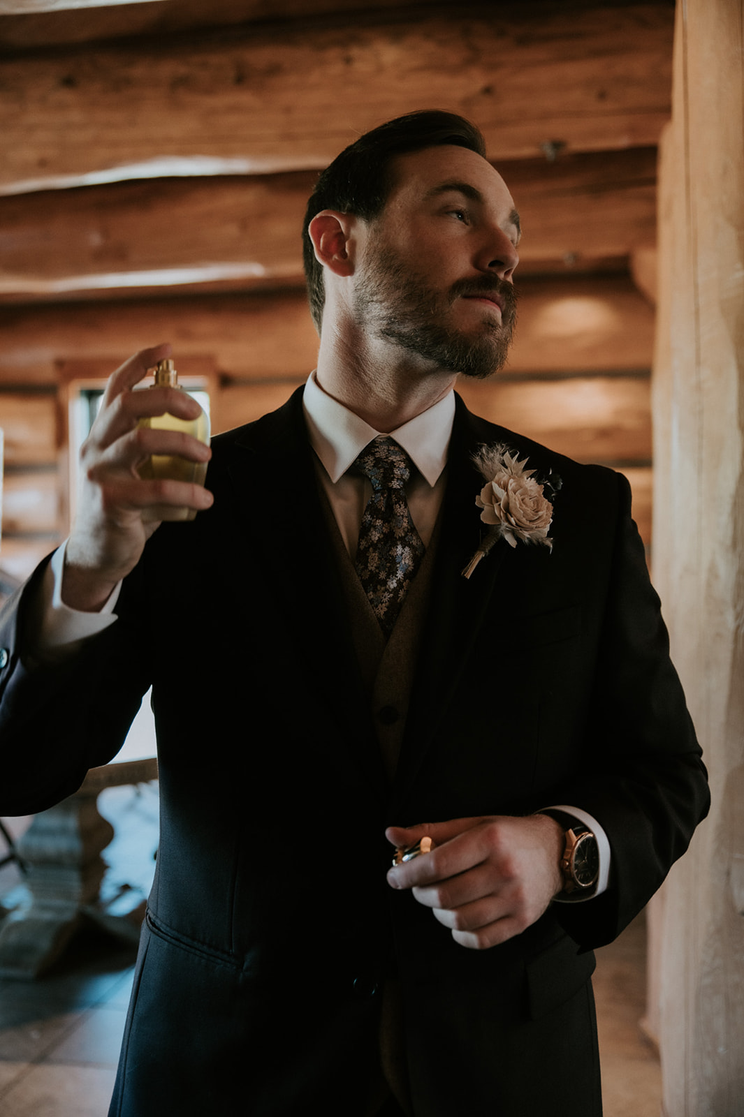 Groom applies cologne before the ceremony, one of the final moments of wedding day preparation.
