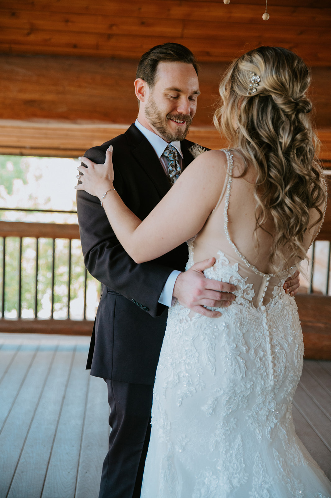 Bride and groom share a private first look on a rustic lodge balcony before the ceremony.
