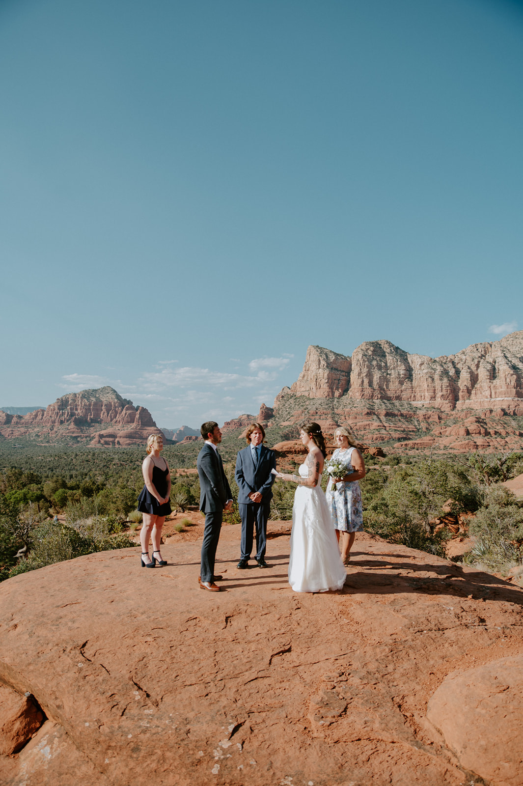 Small family ceremony overlooking Sedona's iconic red rock formations during an intimate eloping in Arizona celebration.