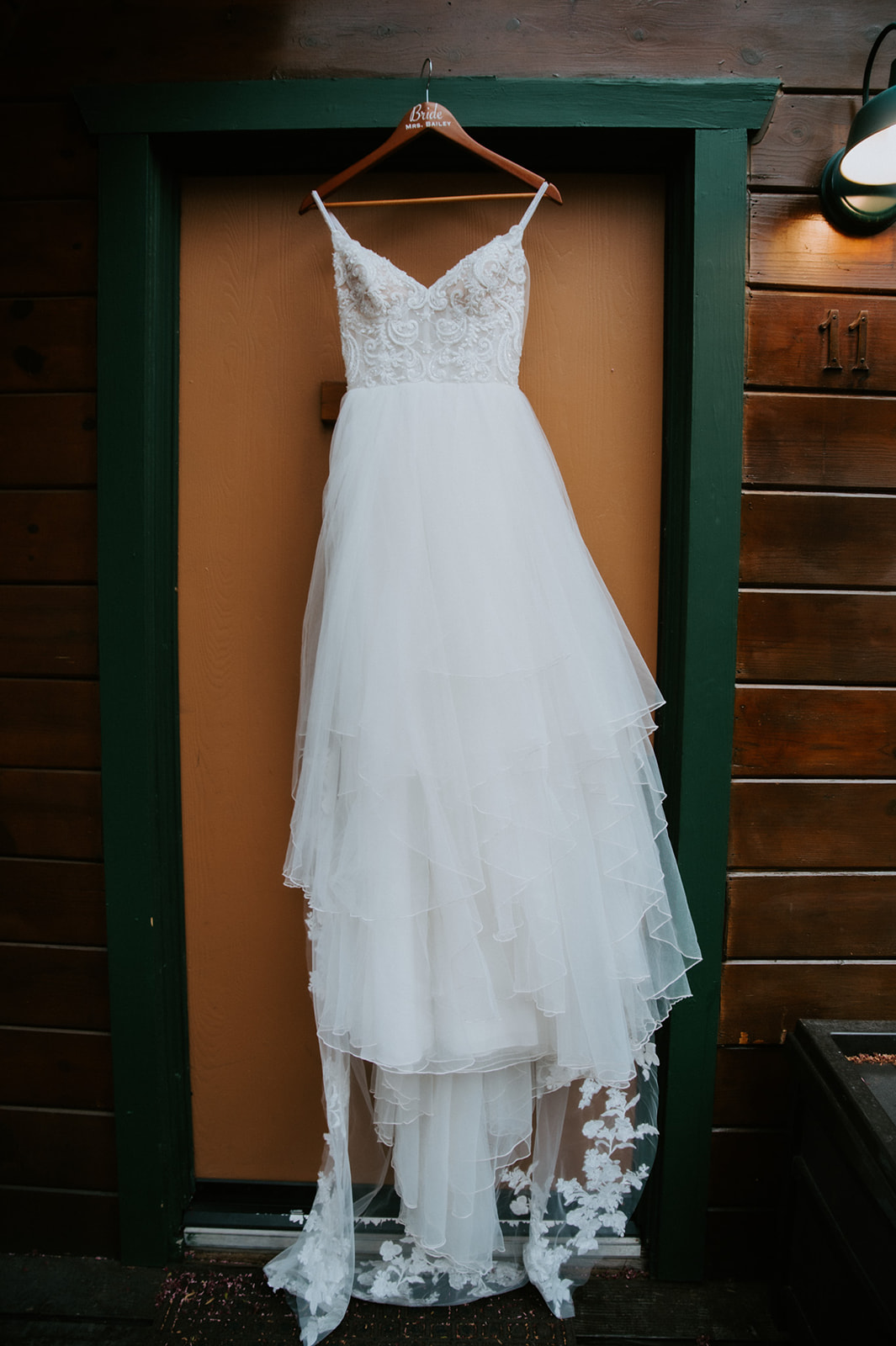 Lace wedding dress hanging from the door of a cabin at Cabins at Strawberry Hill before the ceremony.