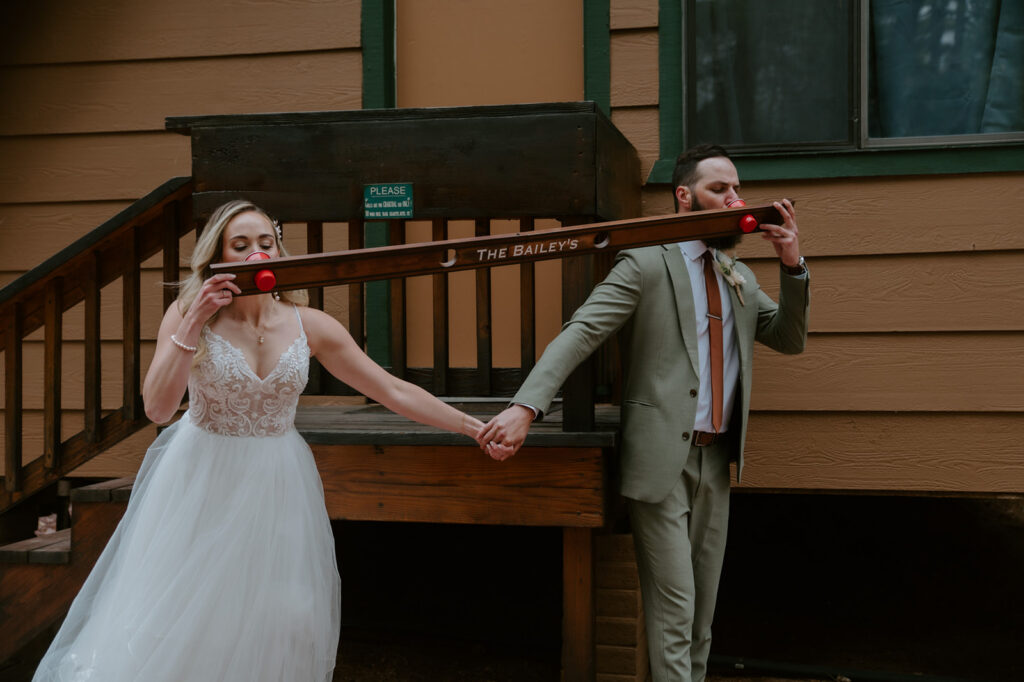 Bride and groom play a personalized wooden drinking game outside their cabin before the wedding ceremony.
