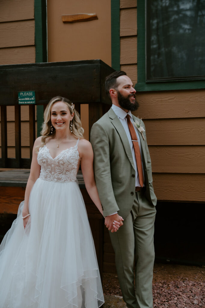 Bride and groom holding hands outside their cabin before seeing each other on their wedding day.