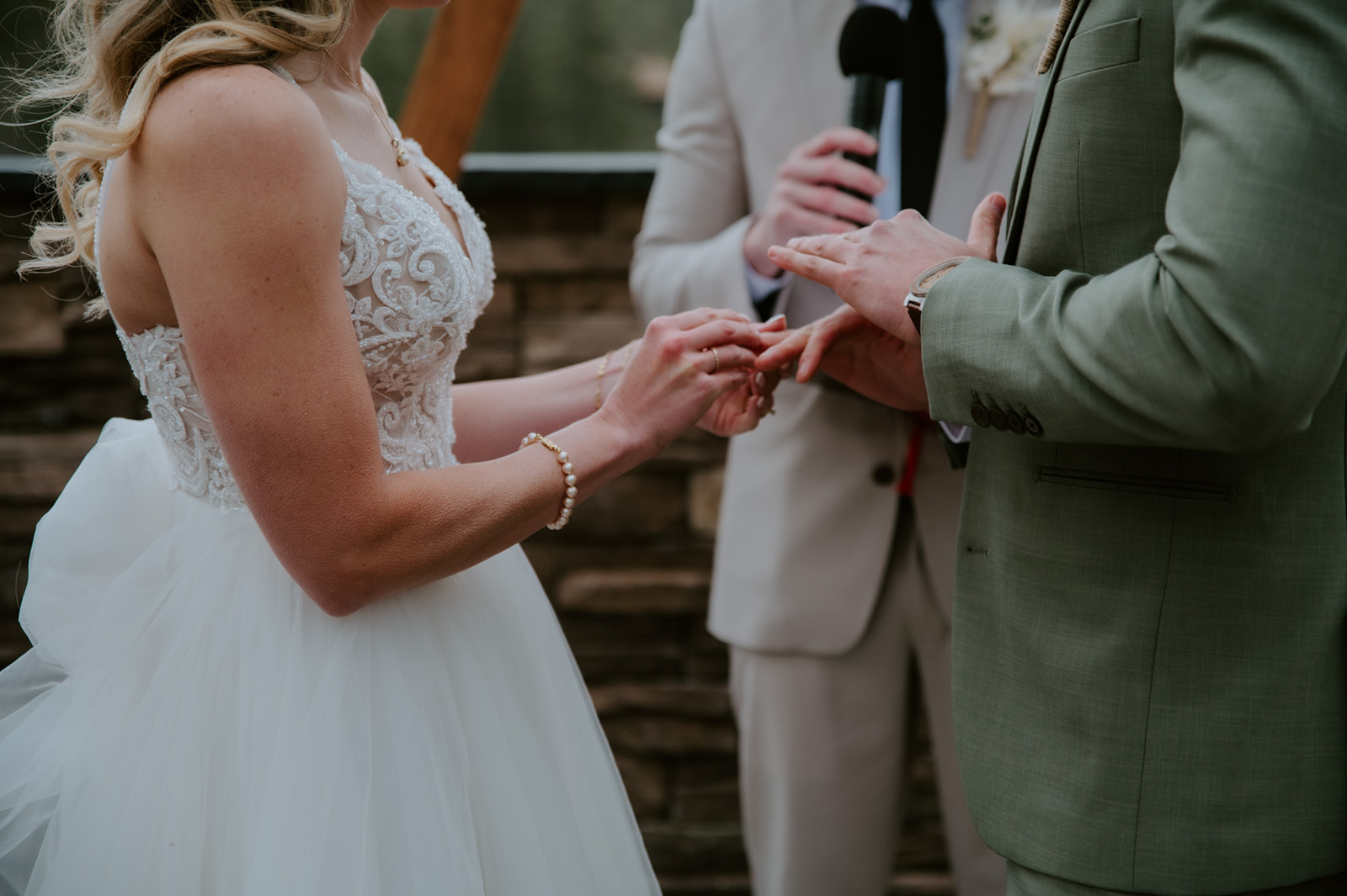 Bride places a wedding ring on the groom's finger during the ceremony at cabins at strawberry hill.
