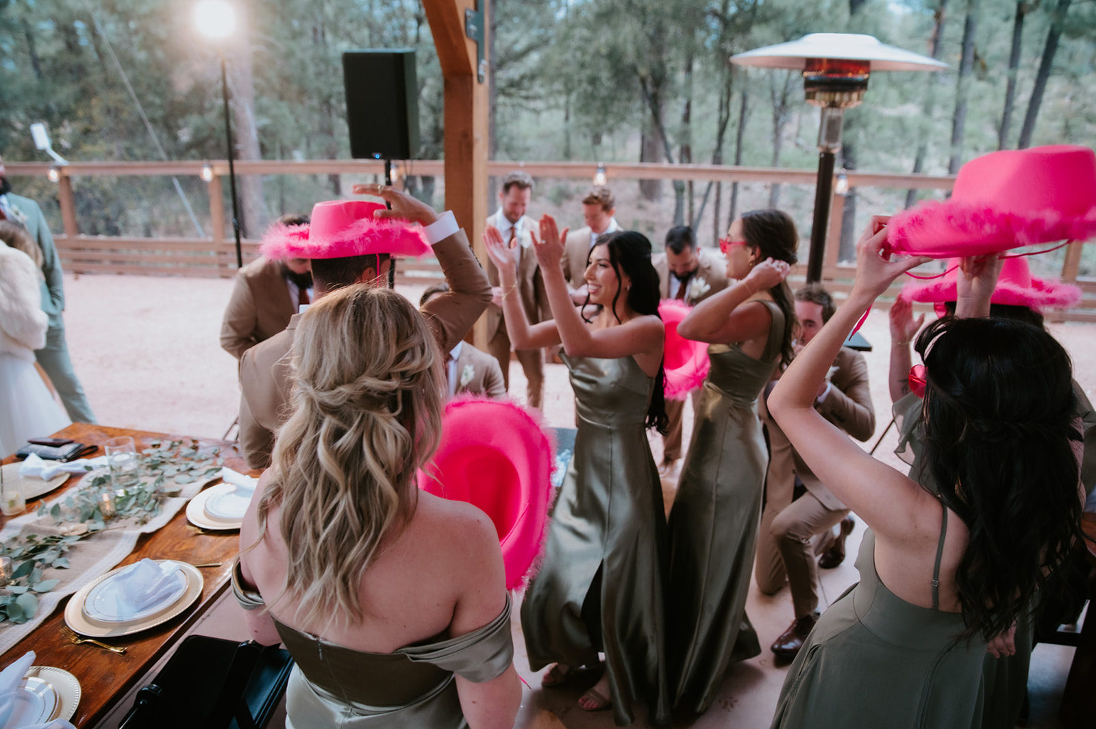 Wedding guests dance with bright pink cowboy hats during the reception at cabins at strawberry hill.
