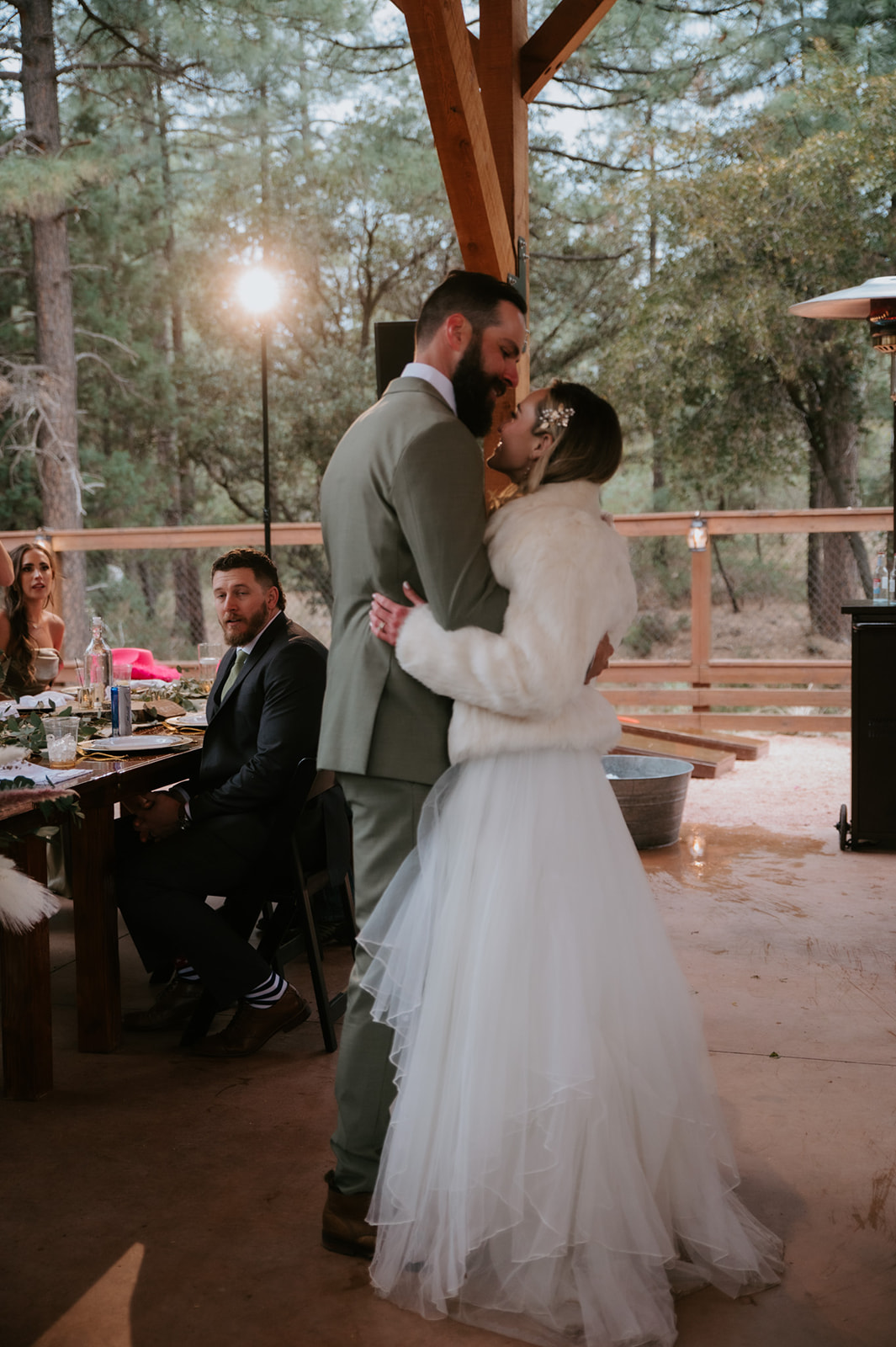 Bride and groom slow dance during their wedding reception while guests watch from nearby tables at cabins at strawberry hill.
