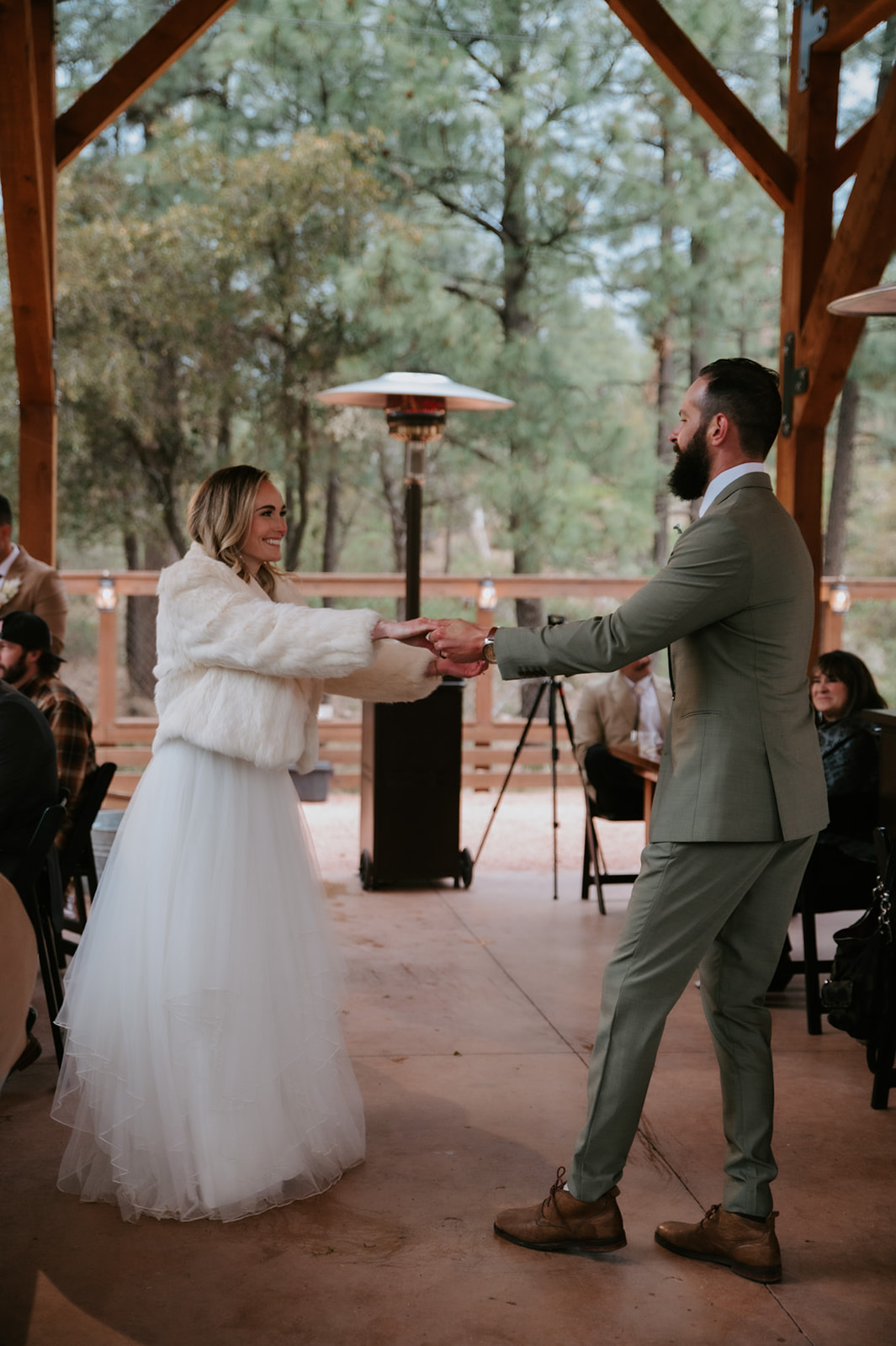 Newlyweds smile as they dance together beneath the covered pavilion at cabins at strawberry hill.
