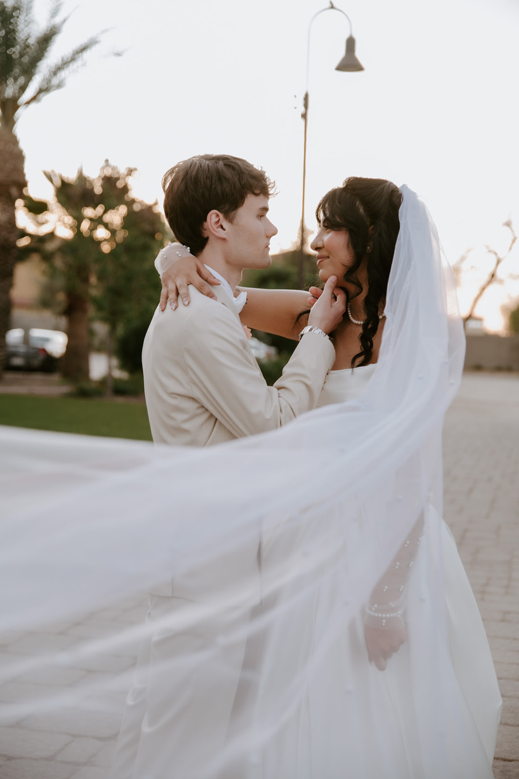 Bride and groom share a romantic portrait outdoors with her flowing veil at Secret Garden by Wedgewood Weddings.
