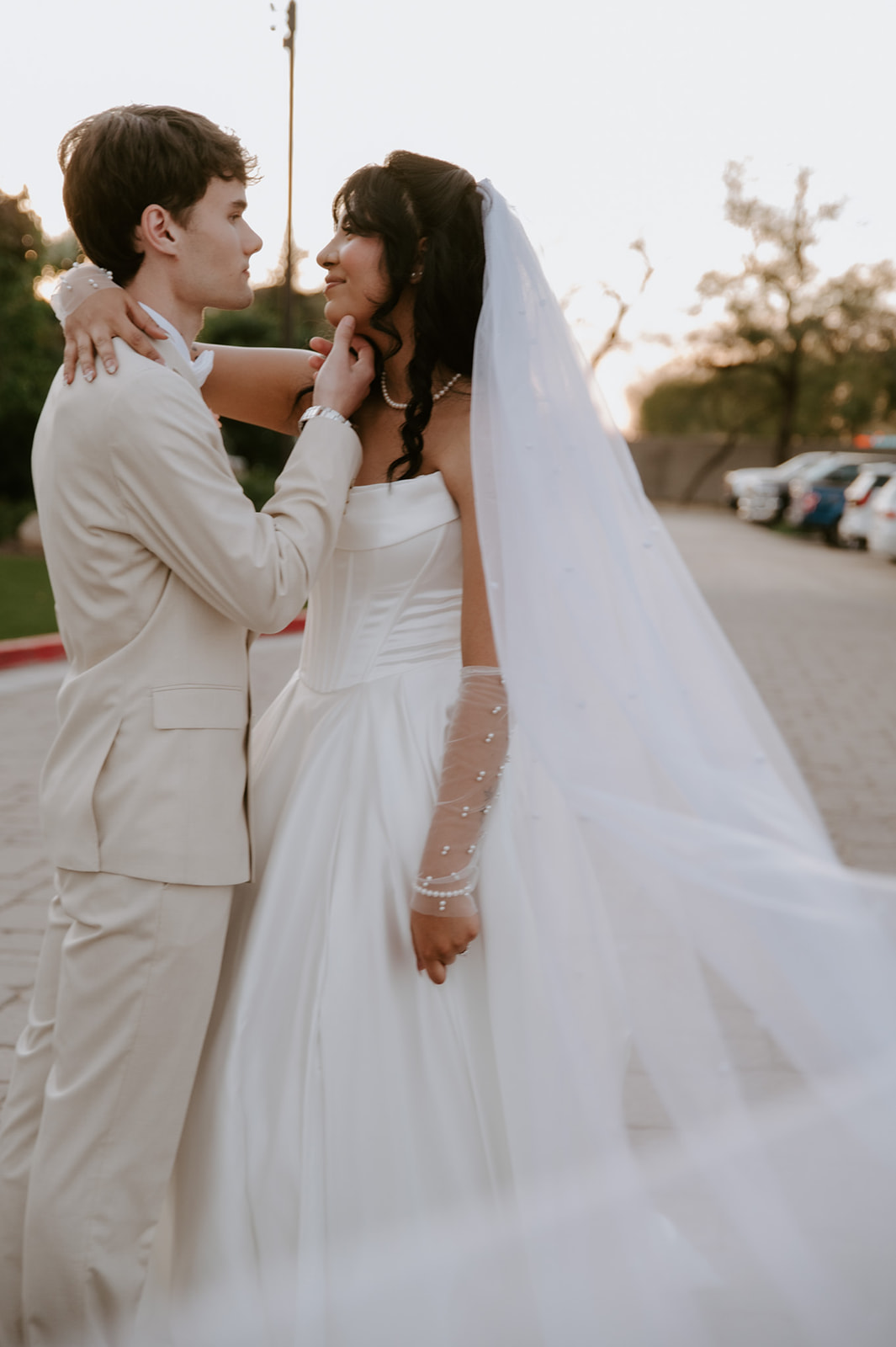 Bride and groom share an intimate outdoor portrait with her long veil flowing behind them at Secret Garden by Wedgewood Weddings.
