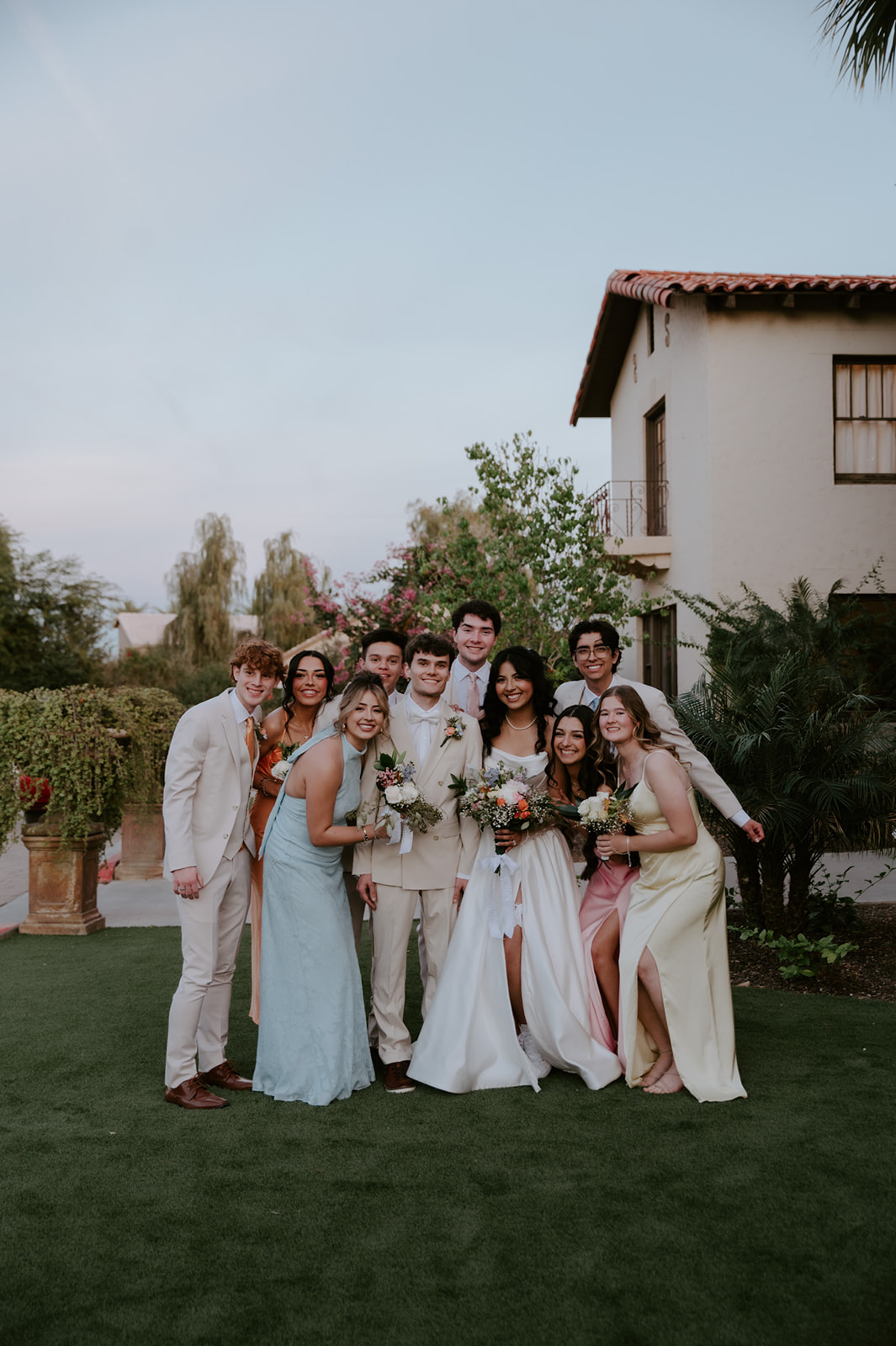 Bride, groom, and wedding party pose together outdoors at Secret Garden by Wedgewood Weddings.
