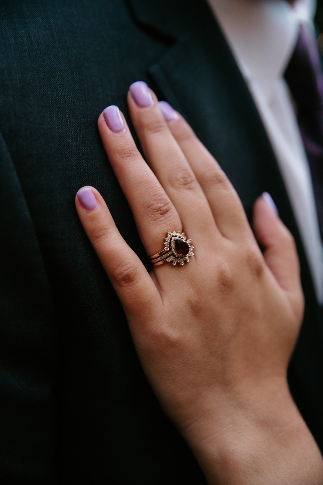 Close-up of a dark gemstone engagement ring with diamond details during a non traditional wedding.