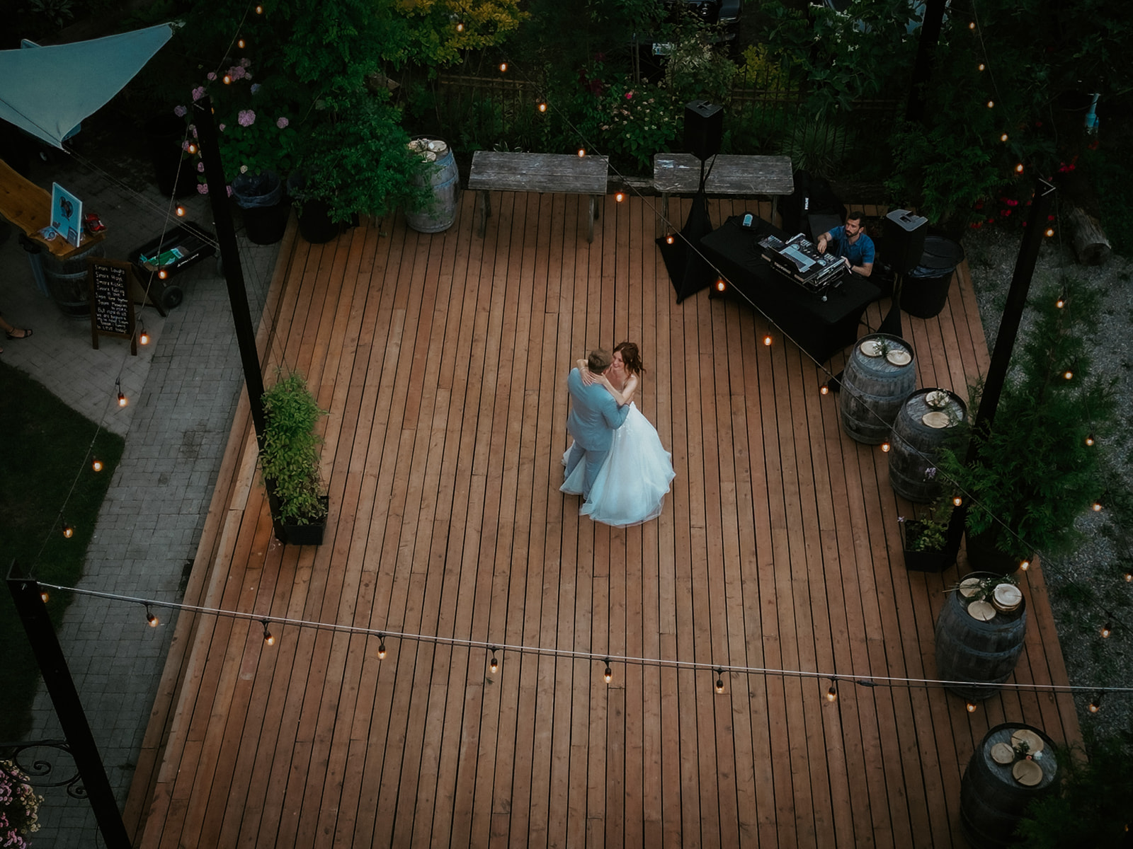 Aerial view of newlyweds sharing a dance beneath string lights at their outdoor wedding in seattle.