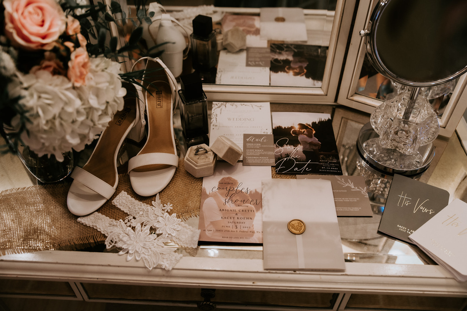 Wedding detail flat lay featuring bridal heels, floral bouquet, rings, invitations, and accessories for a wedding in seattle.