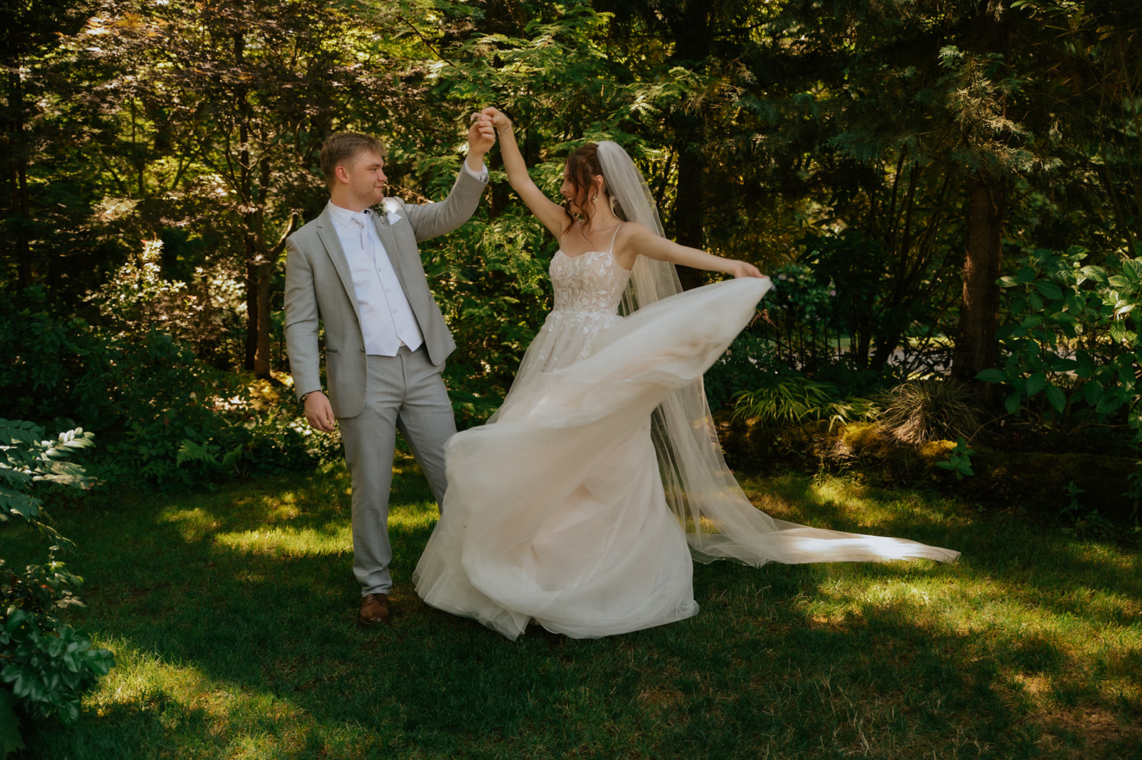 Bride twirling in her flowing wedding gown as the groom holds her hand during their wedding in seattle.