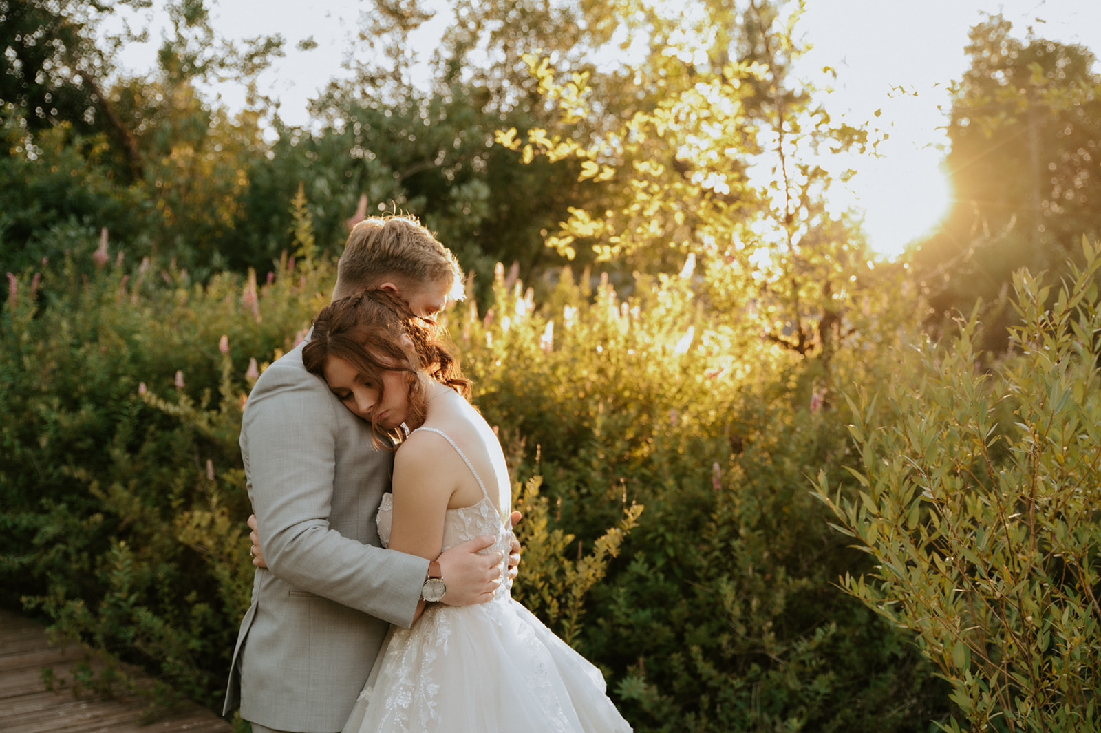 Bride and groom embracing in a sunlit garden surrounded by greenery during their wedding in seattle.