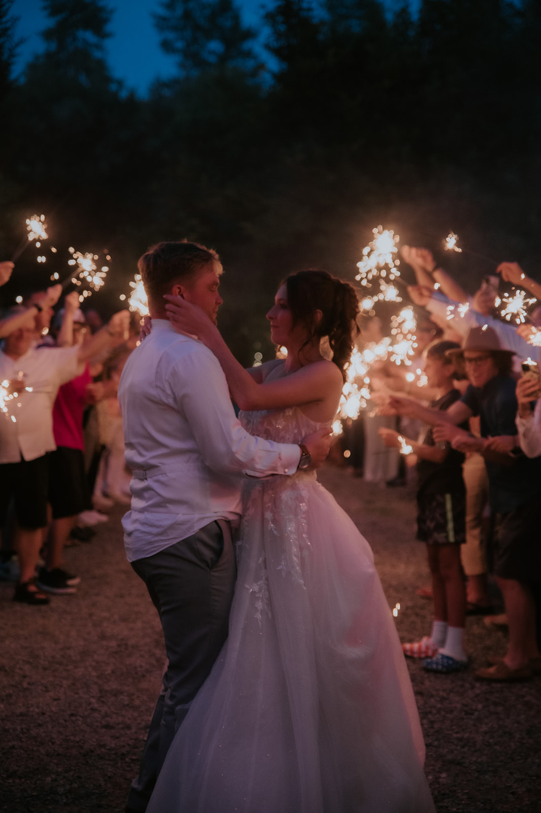 Bride and groom embracing beneath glowing sparklers during their wedding in seattle.